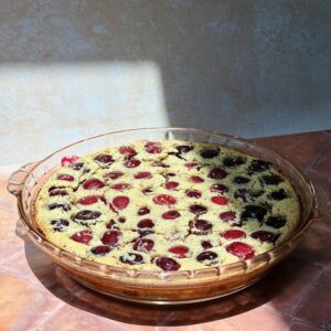 This image sows a cherry clafoutis on that just came out of the oven.