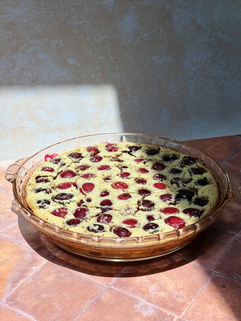 This image sows a cherry clafoutis on that just came out of the oven.